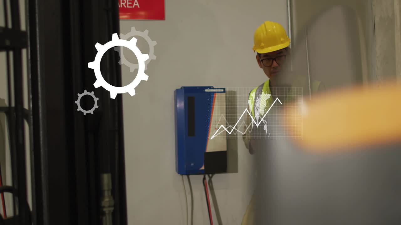 Korean male technician tapping control panel in factory generating animated analytics graphs
