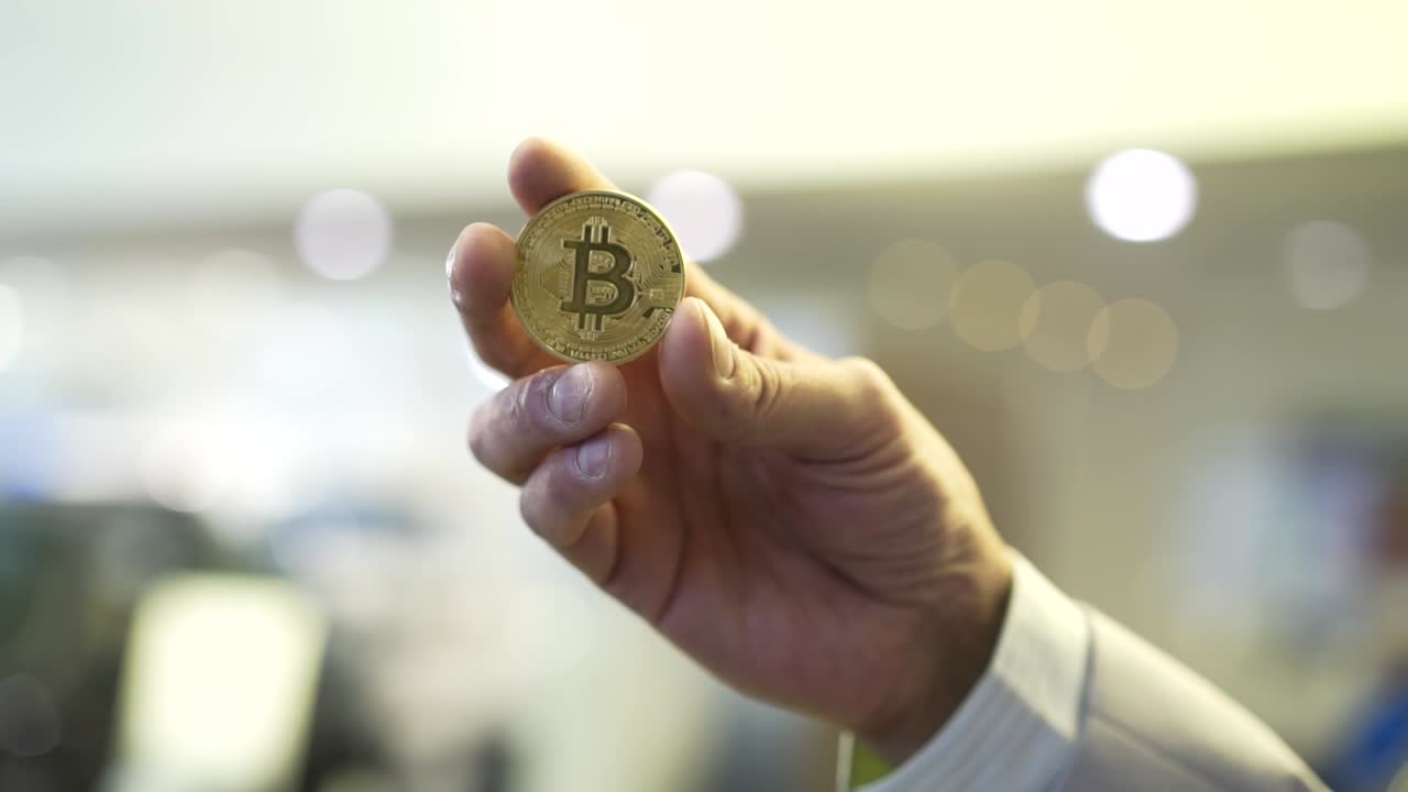 mano con una moneda de bitcoin