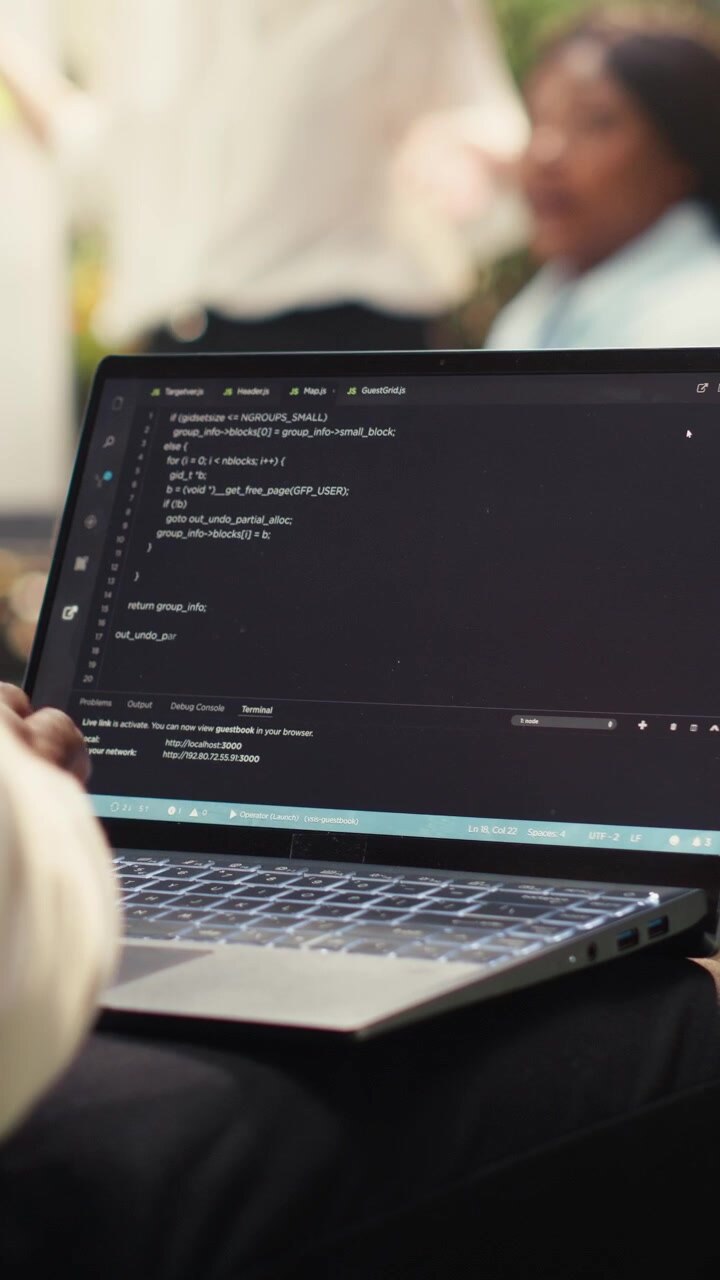 Video Vertical: Empresario programador usando código binario en su portátil durante un trabajo informal