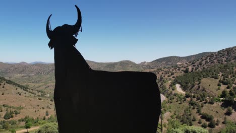 aerial view of toro de osborne, a spanish symbol, huge metal bull on the top of a hill, daylight