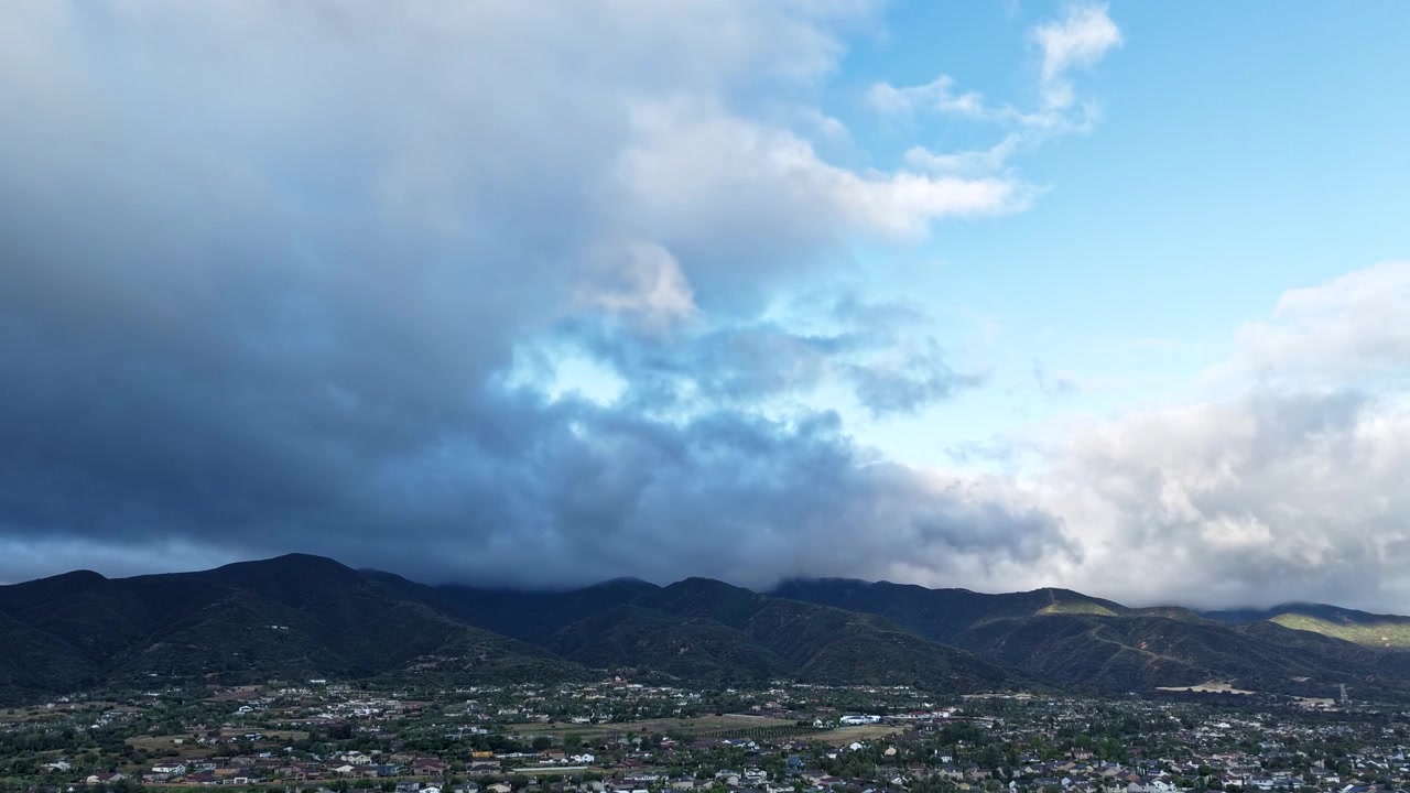Ripresa aerea di nuvole scure che si riversano verso la telecamera, rivelando infine un bellissimo raggio di luce in un timelapse.