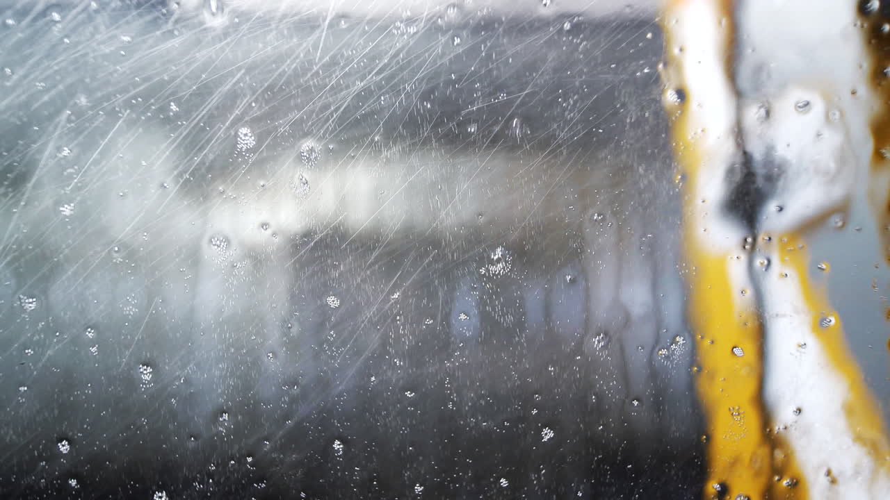 자동 세차 내부 차량 창에 물과 거품 방울