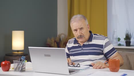 home office worker old man looking at camera with fear and doubt.