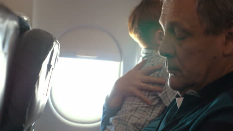 boy and his grandmother hugging in the plane