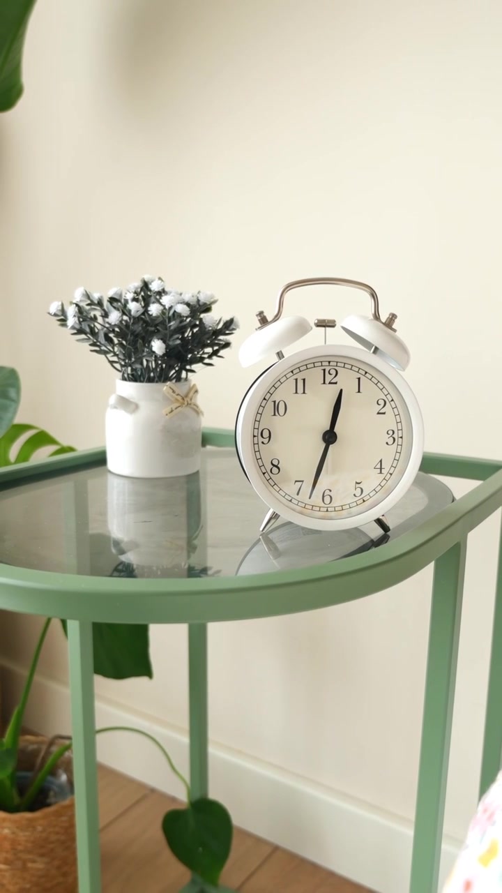 White Alarm Clock on a Green Side Table