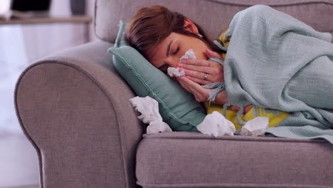 Sick,-cold-and-woman-blowing-nose-on-a-sofa