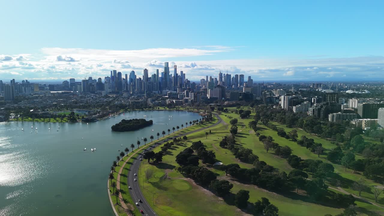 Scenic aerial flight over Albert Park lake in Melbourne on clear summers day with sailing boats racing.