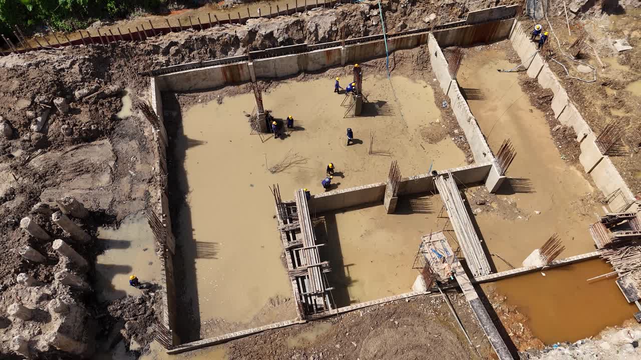 Aerial View of Construction Site with Workers in Muddy Water