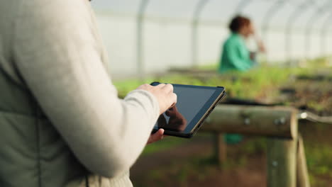 Greenhouse,-plants-and-woman-hands-on-tablet