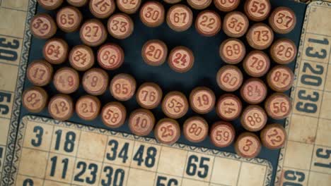 cinematic close-up smooth shot from above of a pile of bingo wooden barrels in a square, woody figures, old numbers background, vintage board game, slow motion 120 fps commercial rotating gimbal video