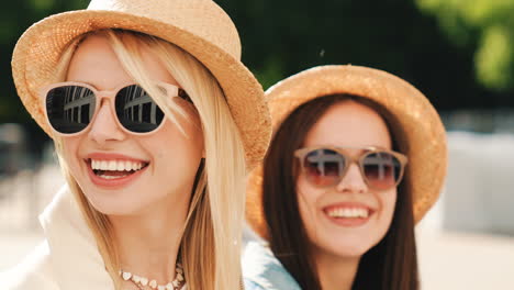 two happy women wearing straw hats and sunglasses