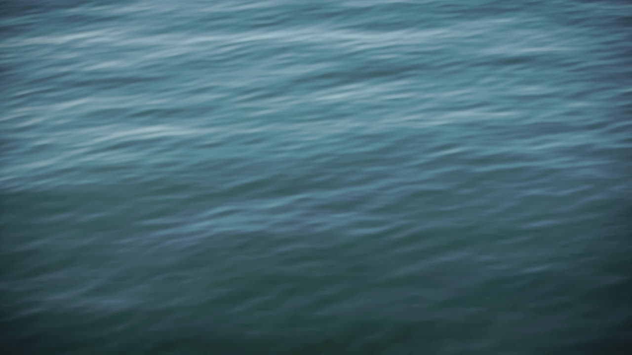 Calm ocean waves roll in, turquoise blue sea, slow motion 4K