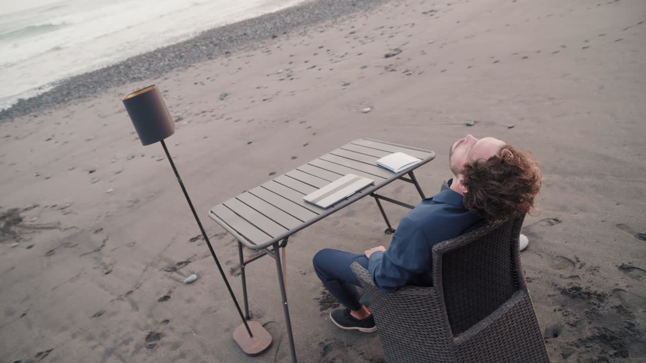 Tired Man Working On Beach At Sunset