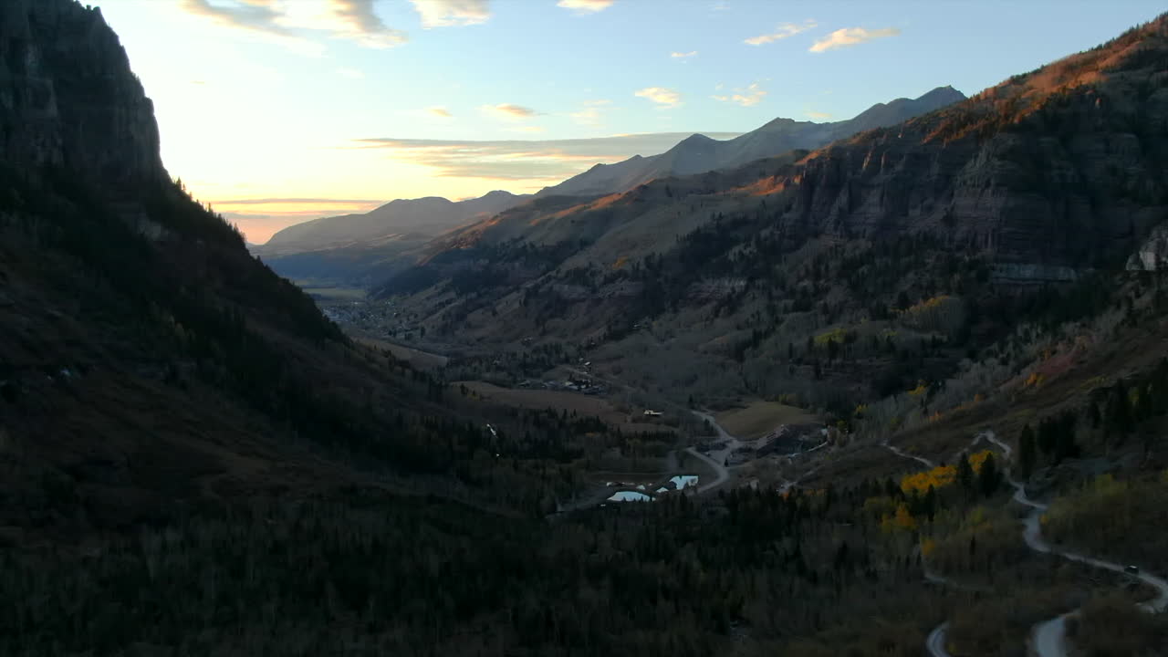 Telluride Colorado: ripresa aerea con drone di fuoristrada 4x4 in una città storica, paesaggio panoramico autunnale con alberi di pioppo tremulo dorati al tramonto sulle Montagne Rocciose, lungo la Silverton Ouray Million Dollar Highway con movimento lento in avanti.