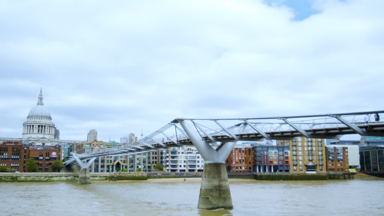 런던 템스 사람들은 시간 경과에 따라 세인트 폴 대성당과 함께 밀레니엄 다리를 걷고 있습니다.