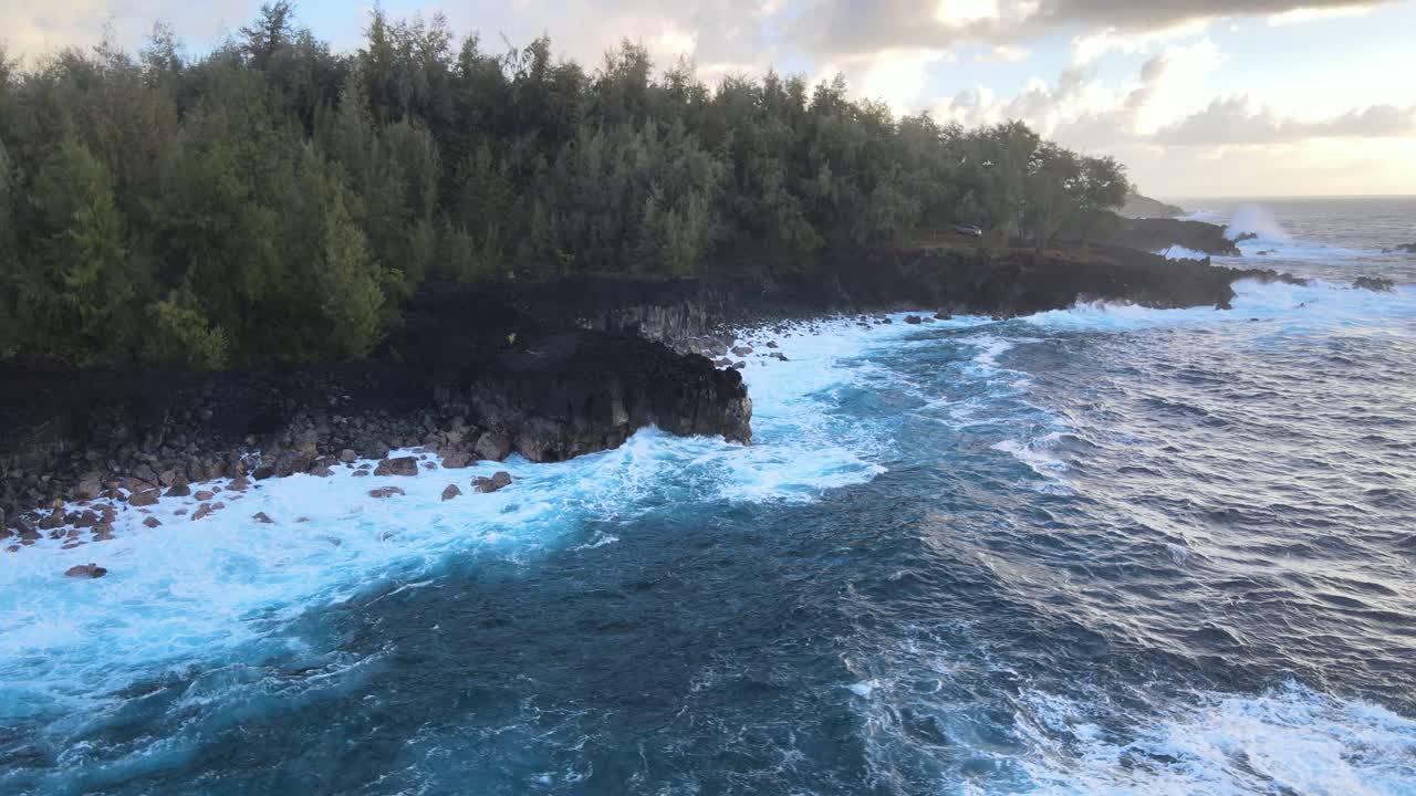En drone cirkler yndefuldt omkring en lille klippe på Big Island, Hawaii, og indfanger den fredfyldte skønhed, mens dybblå bølger blidt kærtegner den barske kystlinje.