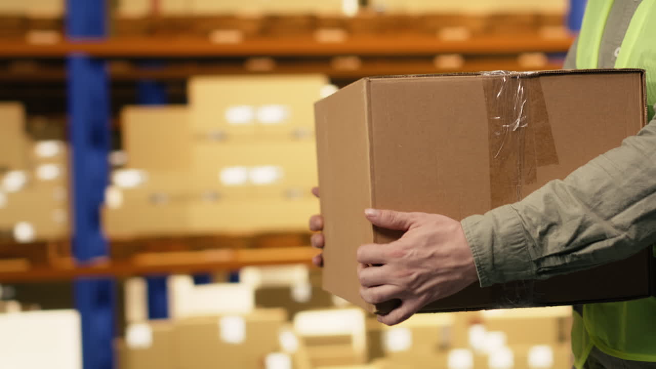 Employee carrying packages, cargo in logistics warehouse, for supply chain