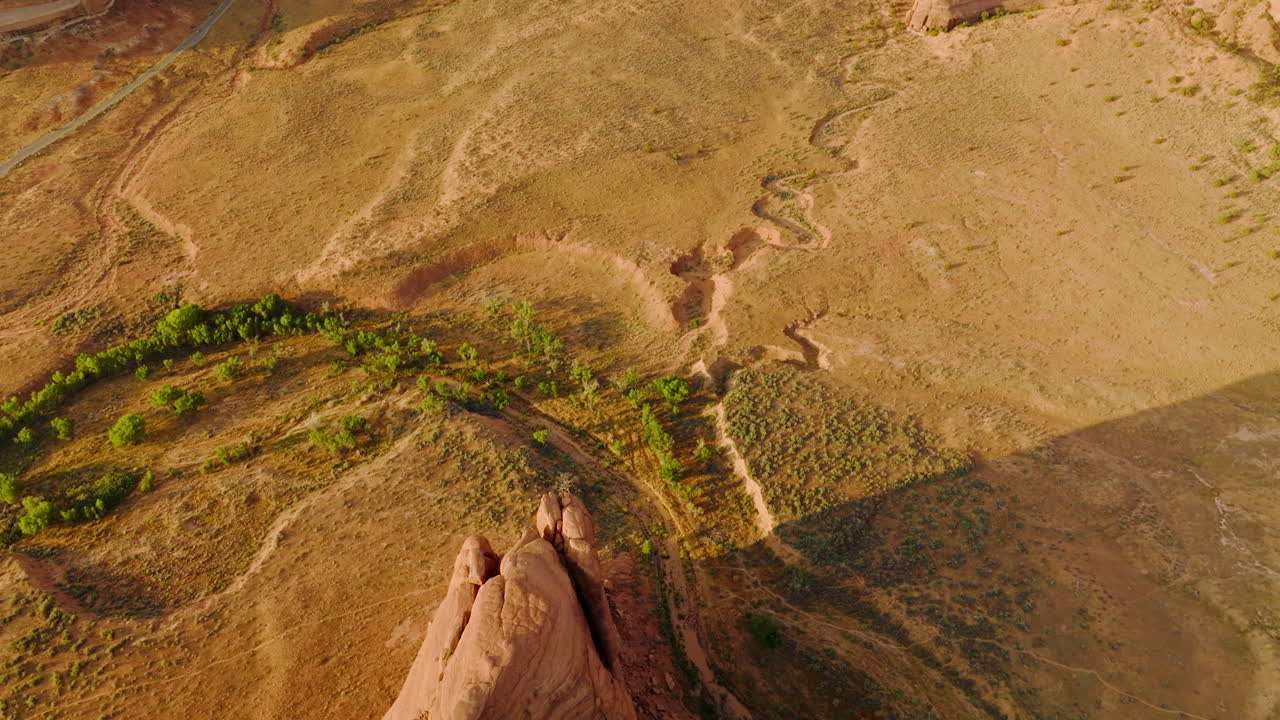 Little greenery growing in the desert landscape. Drone footage over beautiful canyons of Utah, USA.