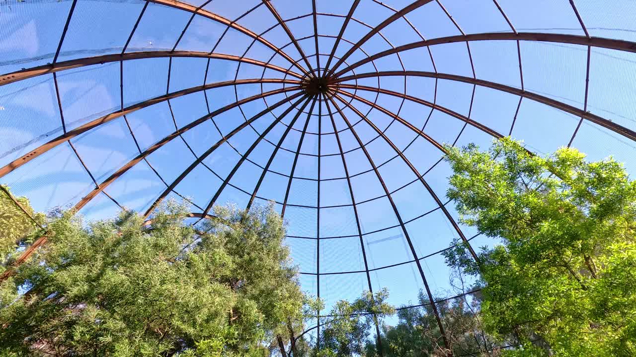 una vista de la cúpula y los árboles del aviario
