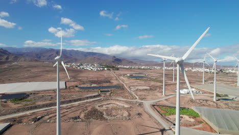 aerial view passing over a field of wind turbines in a desert landscape on the island of gran canaria on a sunny day