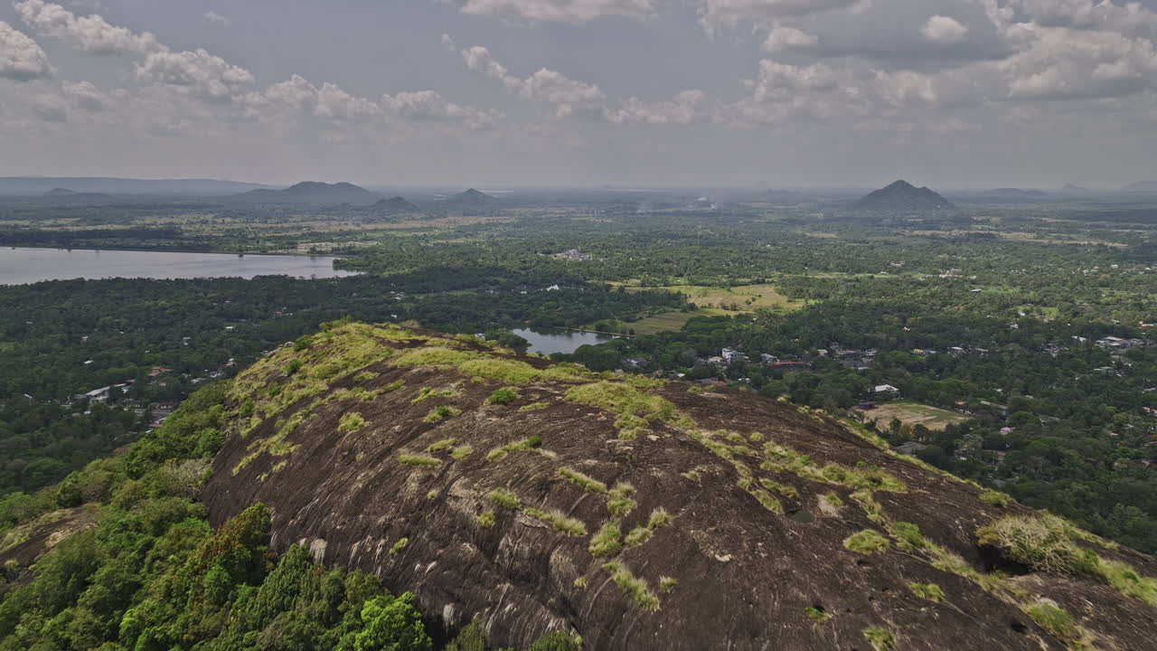 Dambulla Sri Lanka Aerial v5 reverse flyover Isigili mountain capturing royal cave temple, hillside Uyanwatta temple and surrounding landscape of the village town - Shot with Mavic 3 Cine - April 2023