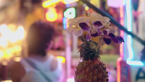 fresh pineapple with flowers against blurred background