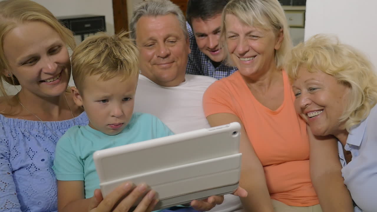 una grande famiglia che guarda un video sul touchpad