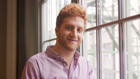 Casually-dressed-red-haired-businessman-smiling-to-camera