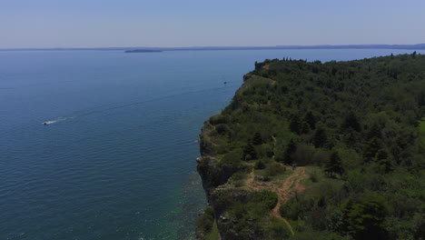 Toma-Aérea-Acercándose-Y-Sobrevolando-Los-Acantilados-De-Manerba-En-El-Lago-Di-Garda-En-Un-Día-Soleado