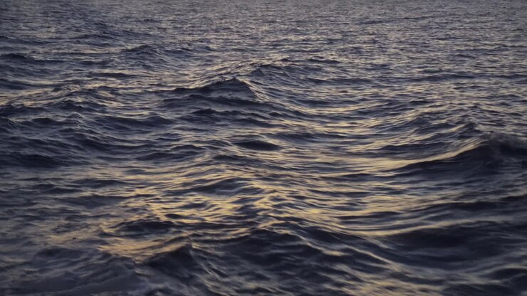 Una vista di rilassanti onde oceaniche al tramonto in estate. POV.