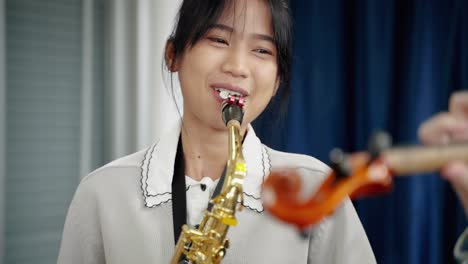 close-up saxophone,asian woman who is a member of a classical band is practicing in a recording studio to prepare for a concert.