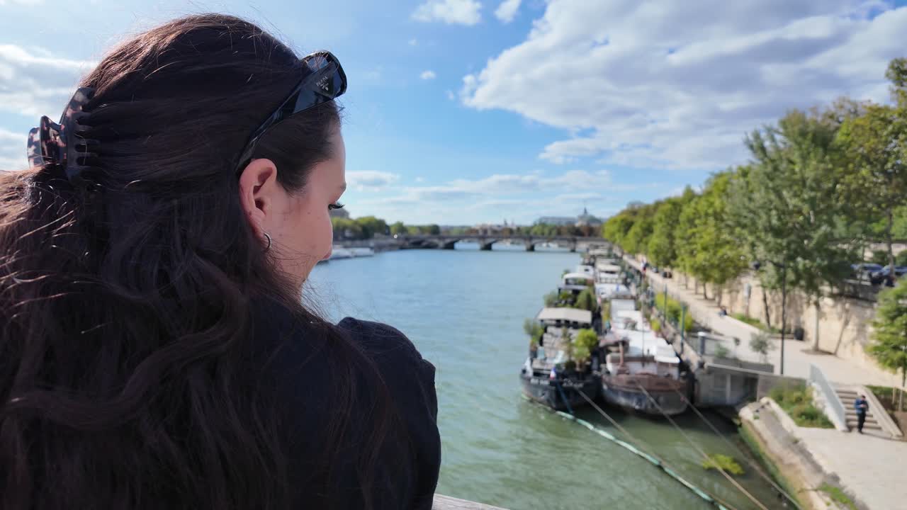 Beautiful brunette girl in Paris France looking at Seine river in summer day