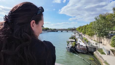 beautiful brunette girl in paris france looking at seine river in summer day