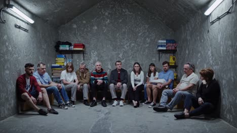 worried men and women sitting together in a dark underground bunker, seeking refuge from conflict, waiting for rescue with hope and resilience