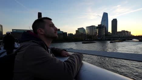man contemplating the london skyline at sunset