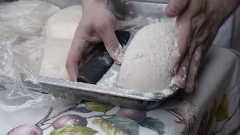 chef takes out the pizza dough from the tray