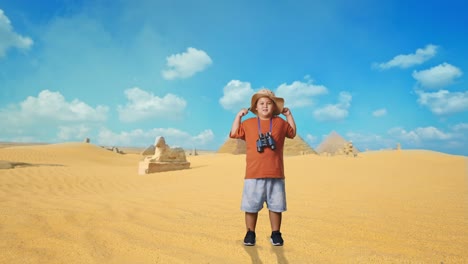 asian boy with a hat and binoculars using the magnifying glass then flexing his bicep while traveling in giza pyramid. boy researcher examines something, travel tourism adventure, full body