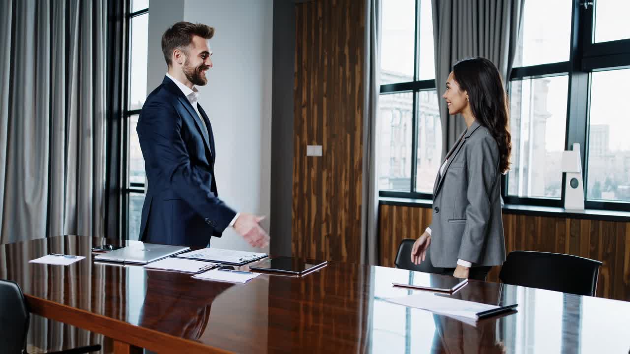 Professional business meeting video concept with a low-angle shot of two executives shaking hands