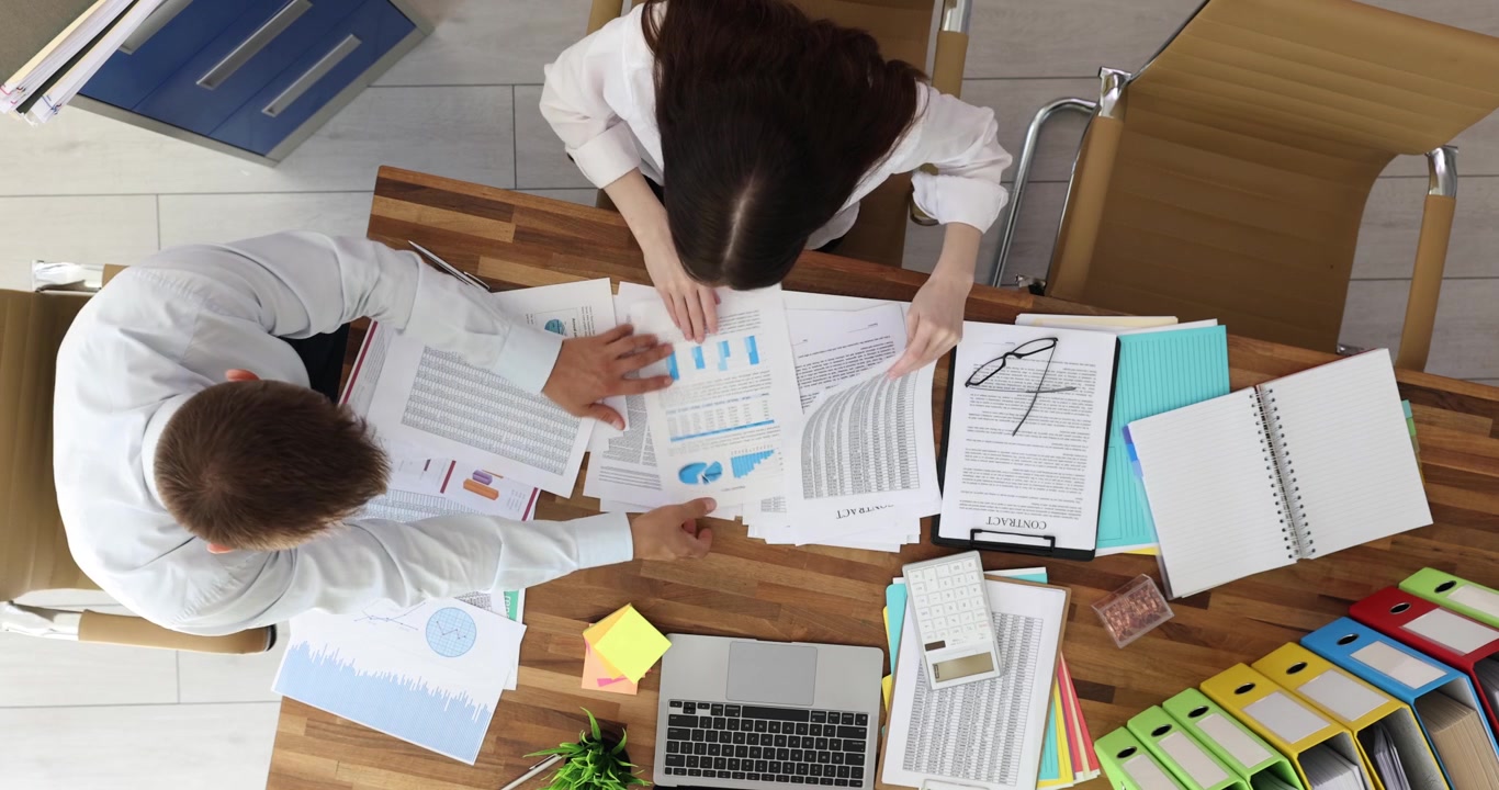 Office workers review documents for upcoming presentation