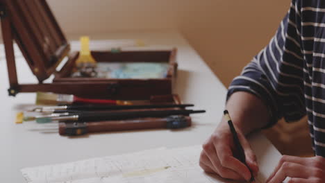 Young-man-sketching-statue-drawing-on-squared-paper-with-pencil