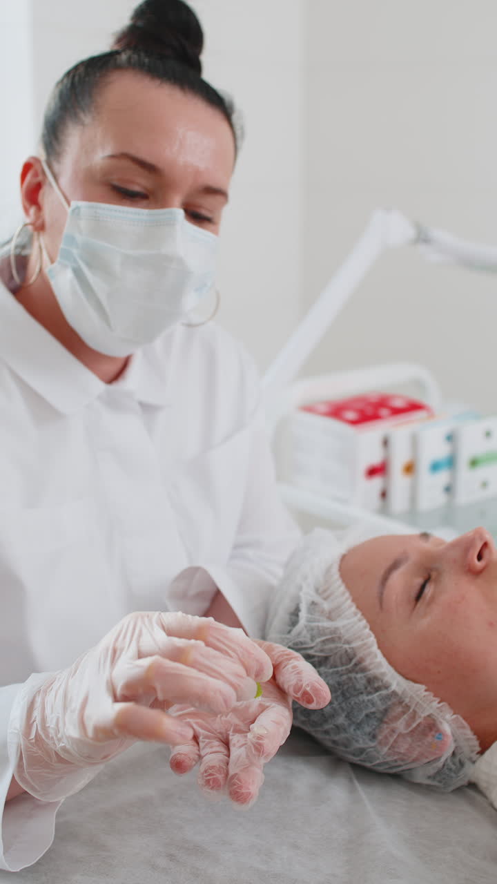Beautician preparing to apply special moisturizing acid scrub peeling face of pretty woman girl