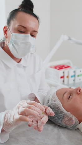 beautician preparing to apply special moisturizing acid scrub peeling face of pretty woman girl
