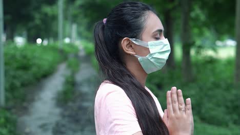 A-close-up-shot-of-a-beautiful-fitness-conscious-young-woman-standing-in-park-with-closed-eyes-and-doing-deep-breathing-exercise