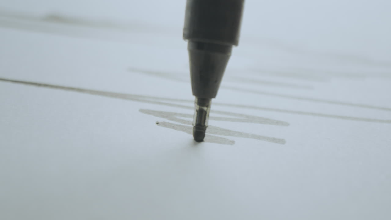 Close-up of a marker drawing lines on paper