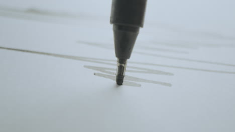 Close-up of a marker drawing lines on paper
