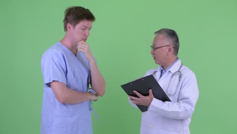 studio shot of doctor and patient talking against green background