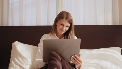 mujer trabajando en la computadora portátil en la cama