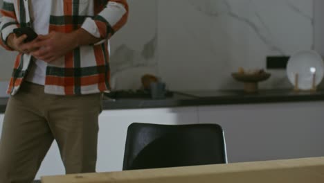 hombre usando un teléfono inteligente en una cocina