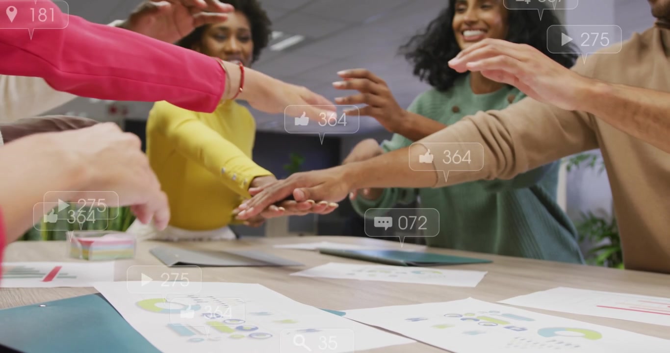 Team leaning and placing hands together after notifications appearing, signaling project commitment