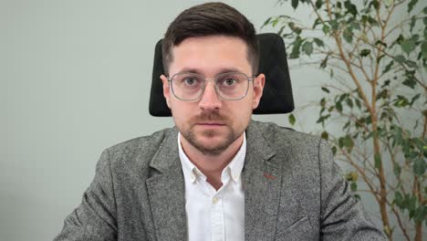 hombre de negocios guapo, trabajador de oficina con gafas, haciendo una llamada de video con el líder de la compañía, reunión en línea, escuchando al orador, acordando, asintiendo con la cabeza, mirando a la cámara, vista de la cámara web, comunicación en internet.